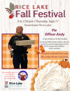 Police officer holding two boxes of pie and smiling at the Rice Lake Fall Festival, with event details and fundraising information in the background, capturing the festive spirit of this beloved Rice Lake tradition. - Rice Lake Chamber of Commerce